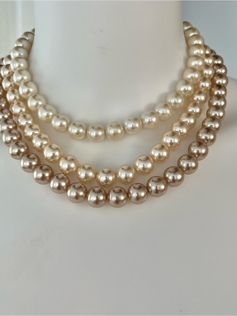 Triple strand cascading cream & champagne tone faux pearl necklace  large clasp